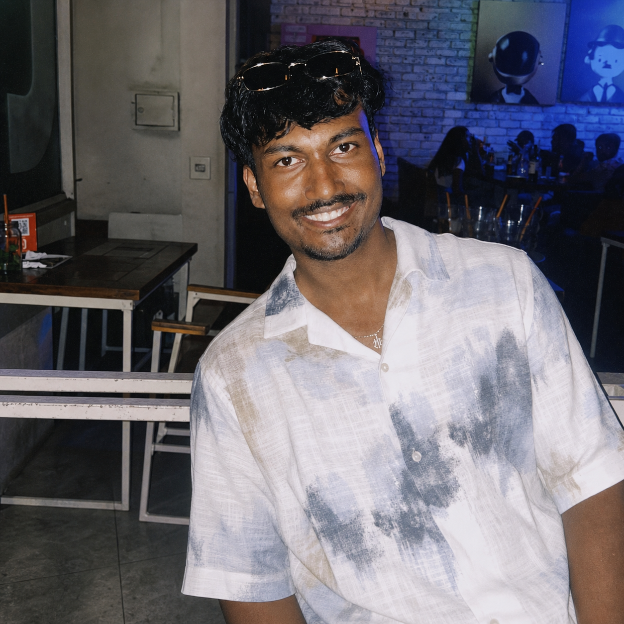Harshith V smiling at a cafe